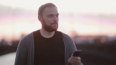 Yakışıklı adam alarak fotoğraf ile a birden parlamak gülümseyerek. Smartphone kullanarak. Modern teknoloji.