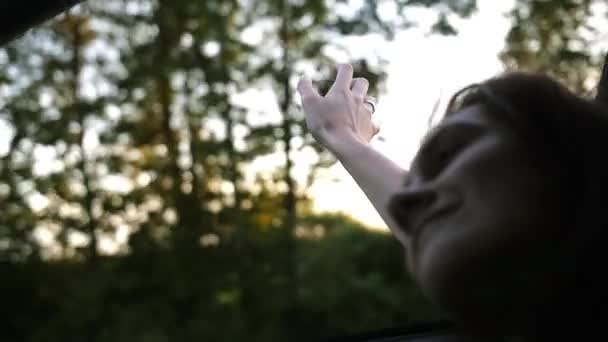 Vy över en kvinna s hand spela med vind. Handen i luften. Ung kvinna i en bil på sommaren. Vinden blåser håret. Långsamma mo — Stockvideo