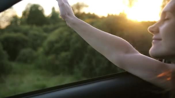Mujer bonita viajando en coche en verano. Mano jugando con viento a través de la ventana de un coche. Hermosa naturaleza. Lento mo — Vídeos de Stock