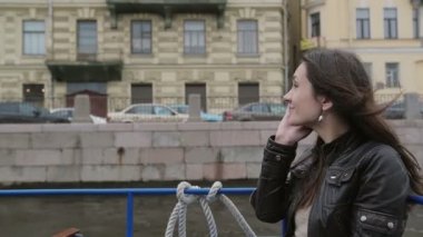 Telefonda konuşurken smartphone, kullanan esmer kız gülümsüyor. Fon kadar yavaş mo asılı bir tekne turuna mutlu kadın
