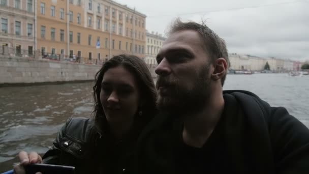 Lovers enjoy a city view on a tour in St Petersburg, taking selfie. Going under a bridge, light goes off and on, slow mo — Stock Video