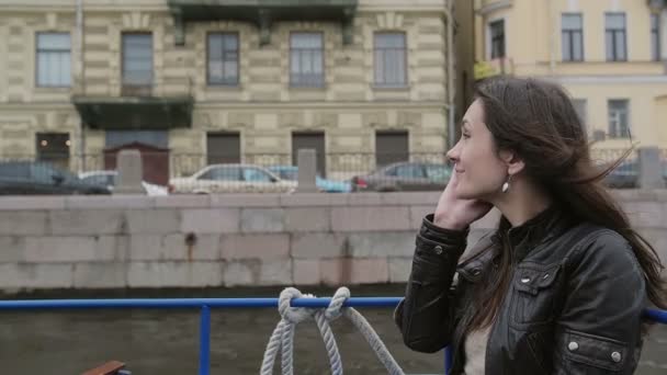 Lächelndes brünettes Mädchen mit Smartphone, telefonierend. glückliche Frau auf einer Bootstour, den Telefonhörer aufhängend, langsam mo — Stockvideo