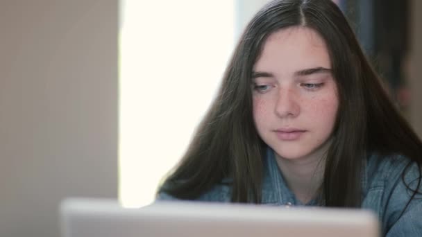 Nahaufnahme von Teenagermädchen mit einem Laptop, die zu Hause am Tisch sitzen — Stockvideo