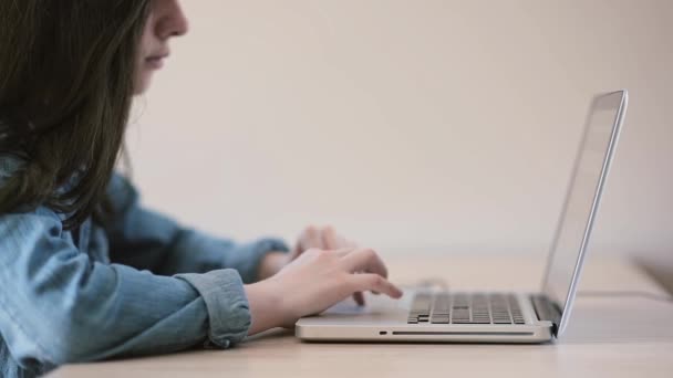 Adolescentes usando um laptop sentado à mesa em casa — Vídeo de Stock