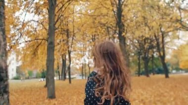 geri görünümü parkta yavaş mo sonbahar sokak boyunca çalışan kıvırcık saçlı mutlu sevimli küçük kız