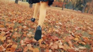 kıvırcık saçlı sevimli küçük kız yakın, park yavaş mo sonbahar sokak boyunca çalışan polka noktaları ile elbise