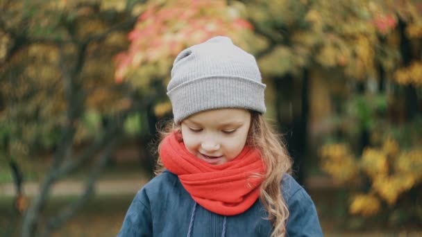 Niña divertida sosteniendo un pequeño ramo y disfrutar del aroma de las flores silvestres en el increíble parque de otoño de cámara lenta — Vídeos de Stock