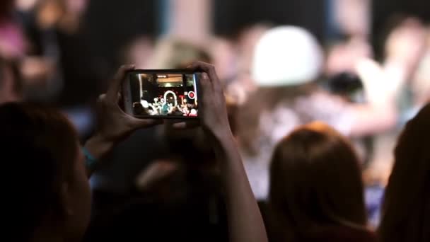 Vista de perto de uma menina furando smartphone e filmando uma dança. Dançando menina pode ser visto na tela de um smartphone . — Vídeo de Stock