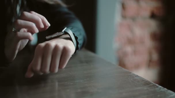 Zbliżenie dłoni. Kobieta za pomocą jej ekran dotykowy urządzenia smartwatch w loft Cafe 4k — Wideo stockowe