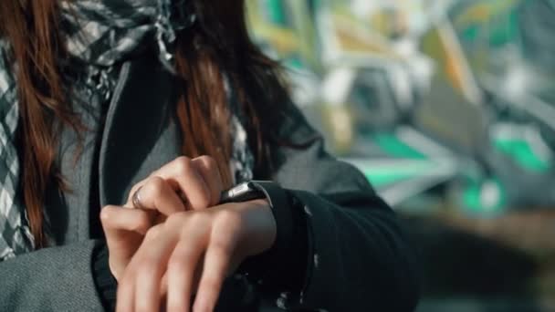 Femme utilisant son appareil tactile smartwatch sur un fond lumineux 4k — Video