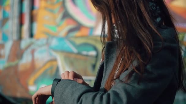Mujer usando su dispositivo de pantalla táctil smartwatch sobre un fondo brillante 4k — Vídeo de stock
