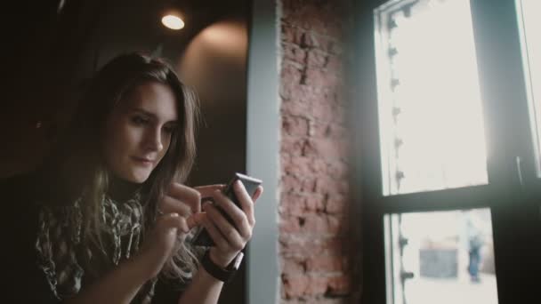 Retrato de cerca. Mujer usando su dispositivo de pantalla táctil smartphon en loft café 4k — Vídeos de Stock