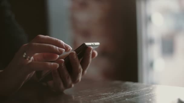 Händer närbild. Kvinna med hennes smartphon pekskärmsenhet i loftet café 4k — Stockvideo