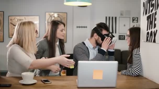 Flot mand forsøger app til VR hjelm virtual reality briller hans venner og kolleger støtter ham i moderne kontor – Stock-video