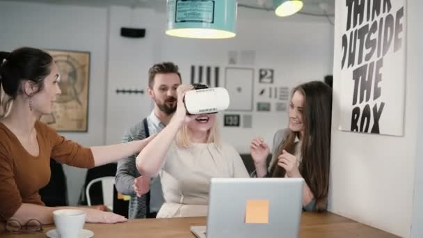 Первый опыт в очках виртуальной реальности молодая команда поддерживает молодую красивую блондинку в современном офисе стартапа — стоковое видео