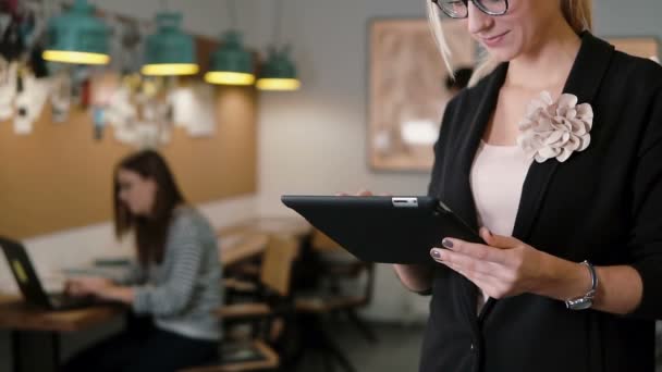 Gros plan belle femme d'affaires blonde utilise tablette dans l'équipe de bureau de démarrage moderne dans le lieu de travail Lent mo, steadicam shot — Video