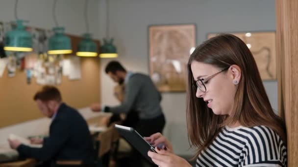 Tatlı güzel esmer iş kadını modern başlangıç office ekibi çalışma alanı yavaş mo steadicam vurdu içinde tablet kullanır — Stok video