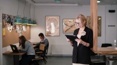 4 k. genç güzel sarışın işkadını dokunmatik tablet modern başlangıç ofiste kullanır..