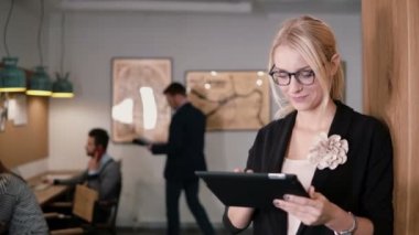 4 k. closeup genç güzel sarışın işkadını dokunmatik tablet modern başlangıç ofiste kullanır..