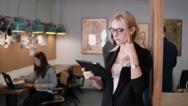 4k. primer plano joven hermosa mujer de negocios rubia utiliza una tableta de pantalla táctil en la moderna oficina de inicio . — Vídeos de Stock