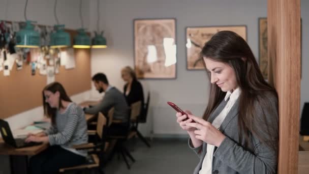 Jeune jolie femme d'affaires brune utilise une tablette à écran tactile dans le bureau de démarrage moderne — Video