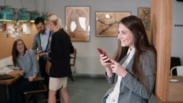 Jeune belle femme brune utilise une tablette tactile mâchant gomme à mâcher rire dans le bureau de démarrage moderne — Video