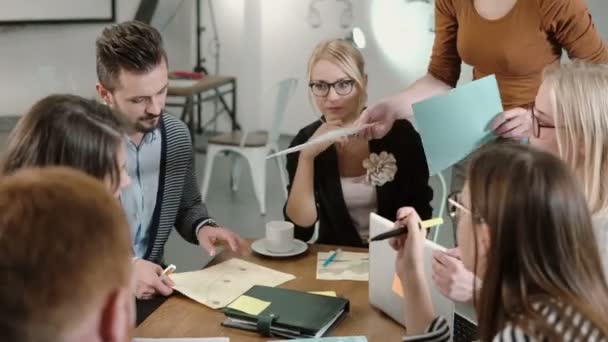 Креативна бізнес команда за столом в сучасному стартап-офісі. Жінка-лідер пояснює деталі проекту . — стокове відео