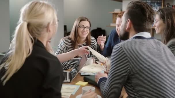 Reunión de creación de empresas en una oficina moderna felices jóvenes hermosos discutiendo activamente nuevas ideas para el proyecto — Vídeo de stock