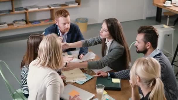 Business-Team mit am Tisch. Treffen verschiedener Menschen, die an kreativen, nachhaltigen Ideen in einem modernen Startup-Büro teilnehmen. — Stockvideo