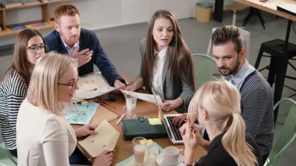 現代のスタート アップ オフィスのテーブルで創造的なビジネスのチーム。女性リーダーは、プロジェクトの詳細を説明します。. — ストック動画