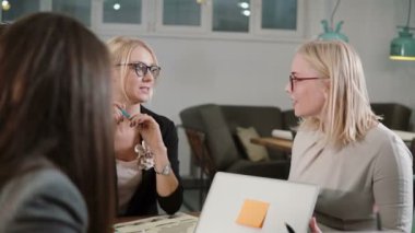 Bir modern coworking alanda takımının iş görüşmesi. güzel sarışın kadın hoparlöre odaklanmak