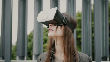 Esmer kadın kız saç sallayarak ile kentsel alanda sanal gerçeklik gözlük kullanır. 4k