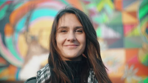 Portret van een jonge shakes hoofd van de vrouw, lacht knipogend op een kleurrijke achtergrond. Close-up. 4k — Stockfoto