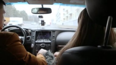 Adam ve kadın arabayla sürüş sırasında söz. Adam sağa dönüyor. Araba ile seyahat.