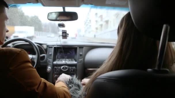 Hombre y mujer hablando en un coche mientras conducen. El hombre gira a la derecha. Viajar en coche . — Vídeo de stock