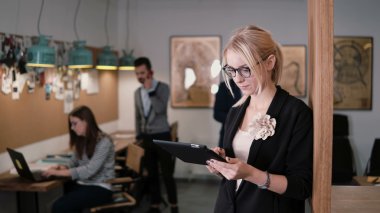 4 k. closeup genç güzel sarışın işkadını dokunmatik tablet modern başlangıç ofiste kullanır..