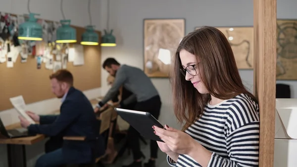 4k. primer plano joven atractiva morena empresaria utiliza una tableta de pantalla táctil en la moderna oficina de inicio . — Foto de Stock