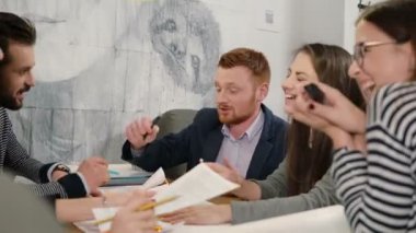 Mutlu yaratıcı küçük işletme takım Genç Mimarlar aktif olarak yeni fikirler tartışırken başlangıç ofiste Toplantı