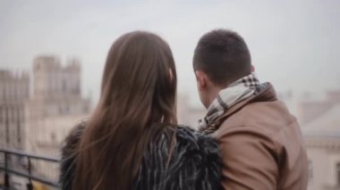 Şehir manzarayı bir çatının arka ve yan görünümü severler. Öp, gülümseme birbirleriyle konuşmak. Soğuk sisli hava.