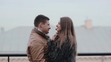 Güzel genç çift şefkatle kucaklayan, birbirlerini öpmeye. Uyum ilişki içinde. Seven çift bir çatı üzerinde.