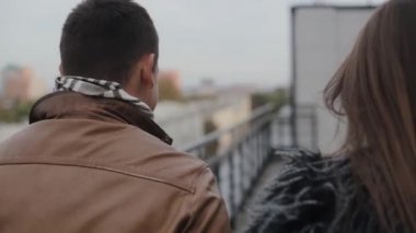 Mutlu aşk. Koyu renk saçlı bir çiftin bir çatı yürüme, öpüşme Backview. Uyum içinde ilişki.