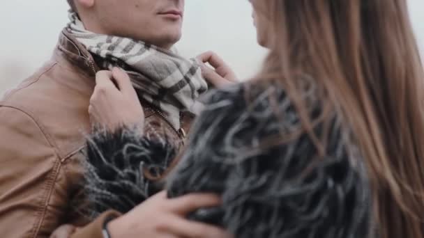 Mooie mensen in liefde. De vrouw stelt haar minnaar s sjaal rechte. — Stockvideo