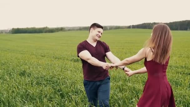 Aantrekkelijke paar genieten van hun tijd samen, wandelen via een tarweveld, houden van de handen, langzame mo, steadicam schot — Stockvideo