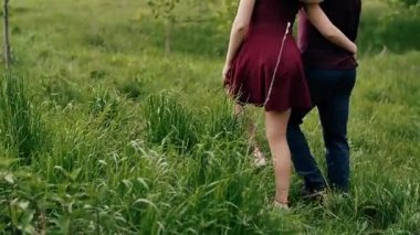 Güzel çift yürüyüş yaz, bahçesinde birbirlerini kucaklamak. Mutlu aşıklar doğada. Backview, yavaş mo, steadicam vurdu