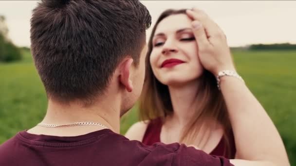 Close-up de uma mulher bonita feliz olhando para seu homem e beijando-o. Natureza no fundo. Slow mo, steadicam shot — Vídeo de Stock