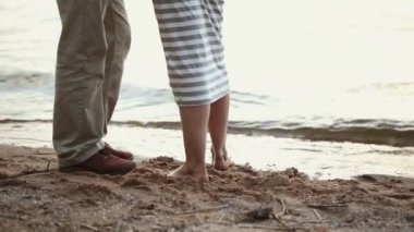 Bacak kumlu bir plaj üzerinde genç çiftin yakın çekim. Kız suya geliyor.