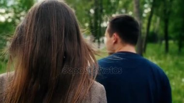 Arkadan görünüş Park'ta yürüyordunuz aşık romantik genç çiftin. Steadicam yavaş mo vurdu