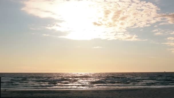 Zachte zonnestralen oplichten van het oppervlak van de golven komen naar de kust — Stockvideo