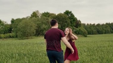 Mutlu çift aşık doğada iyi eğlenceler. Güzel genç kadın aşık kollarına atlar. Yavaş mo, steadicam vurdu