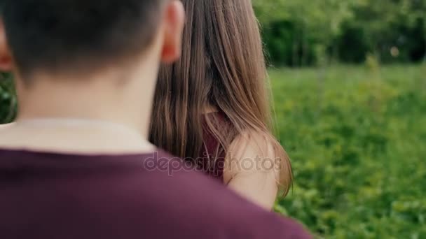 La mano de las mujeres toca las hojas. Hermosa joven mujer camina delante de su hombre, gira la cabeza Backview lento mo, steadicam disparo — Vídeos de Stock